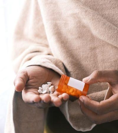 Person Pouring Pills Into Her Hand