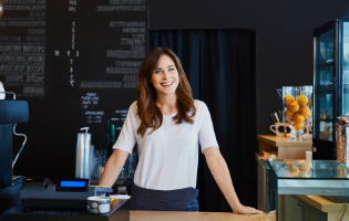 Woman Standing Behind a Table