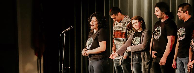 Students standing on a stage.