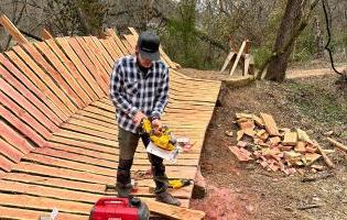 Man Holding a Tool on a Wooden Trail