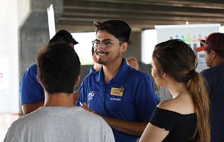 Male student smiling and talking to other students